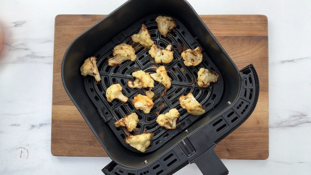 half cooked cauliflower florets in the air fryer basket