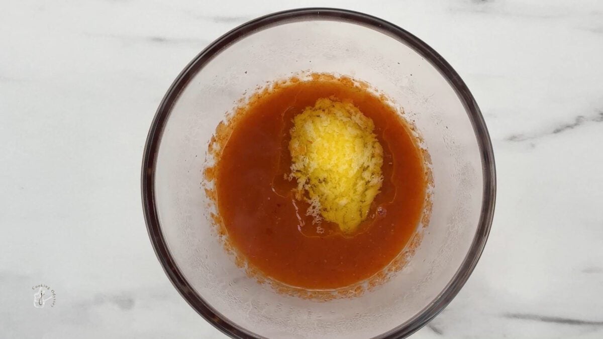 butter and hot sauce heated together in a bowl in microwave 