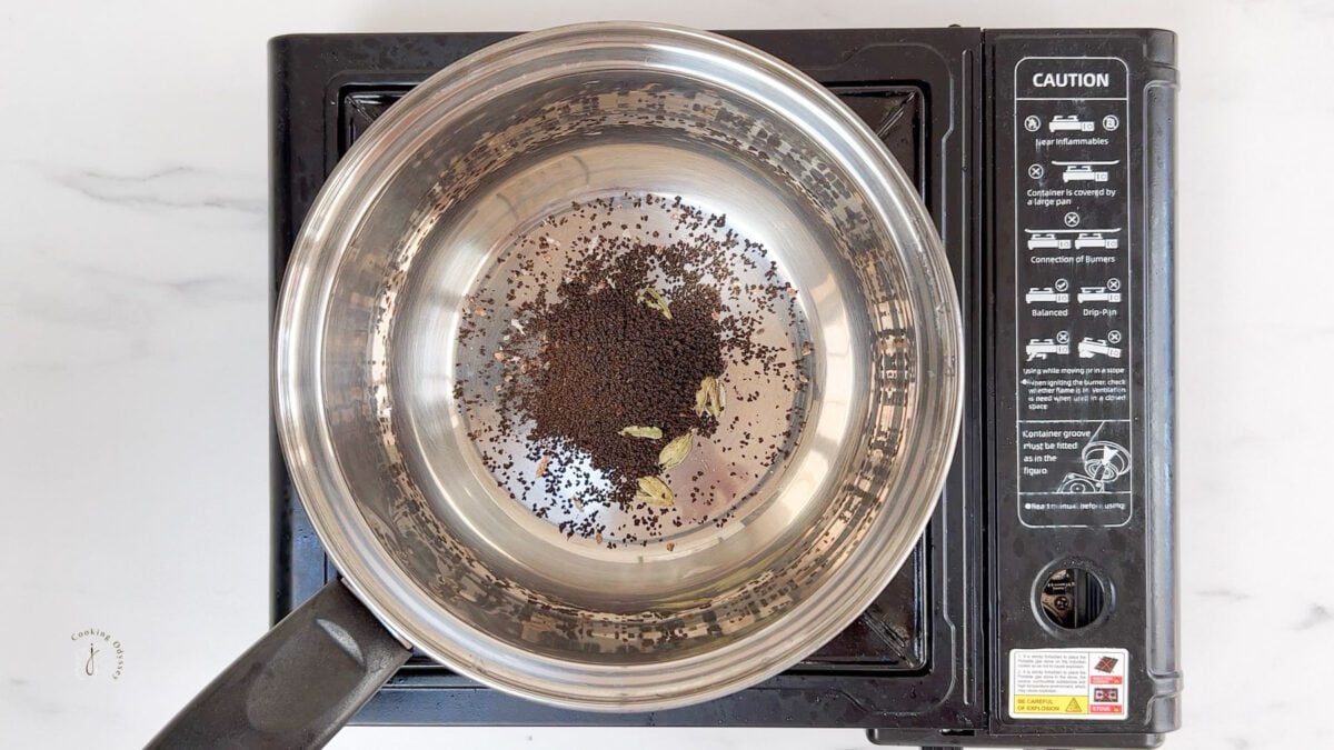 crushed cardamom and loose black tea in the pan to make cardamom tea