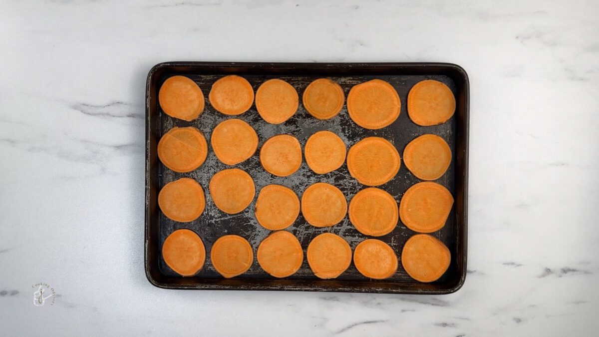 raw sweet potato cut slices arranged on to the baking tray