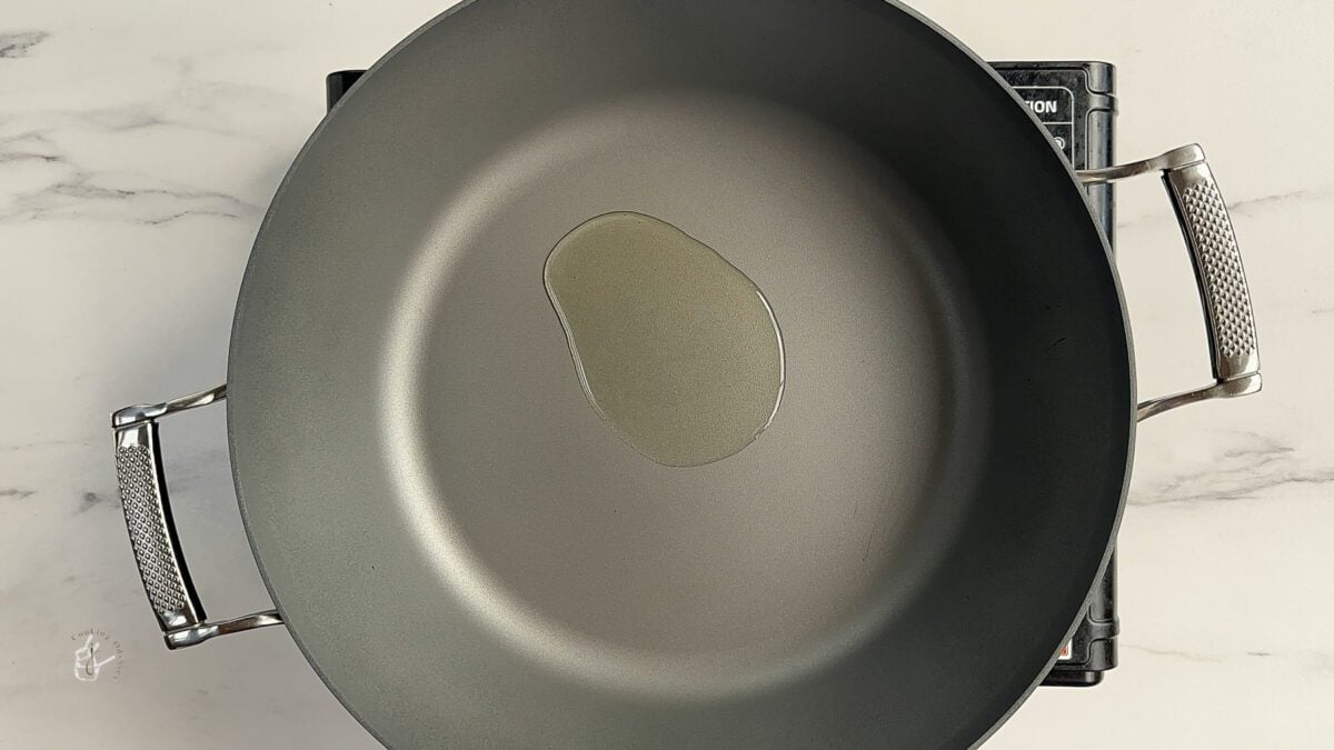 oil heating in the large frying pan to make cabbage curry