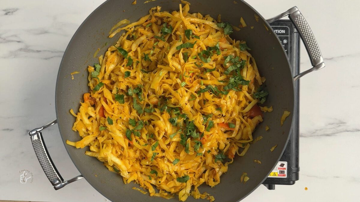 North Indian style cabbage ki sabzi garnished with fresh coriander in the frying pan
