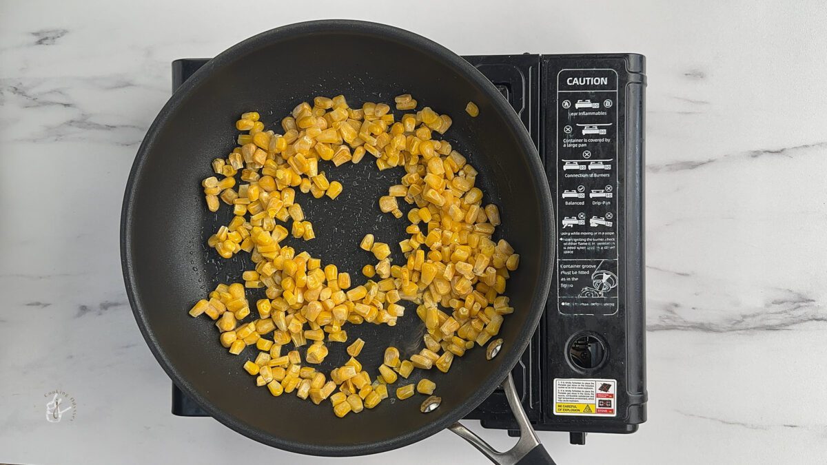 corn kernels cooking in the pan to make sweet corn chaat