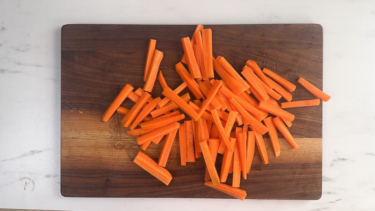 thinly cut carrot sticks on a chopping board