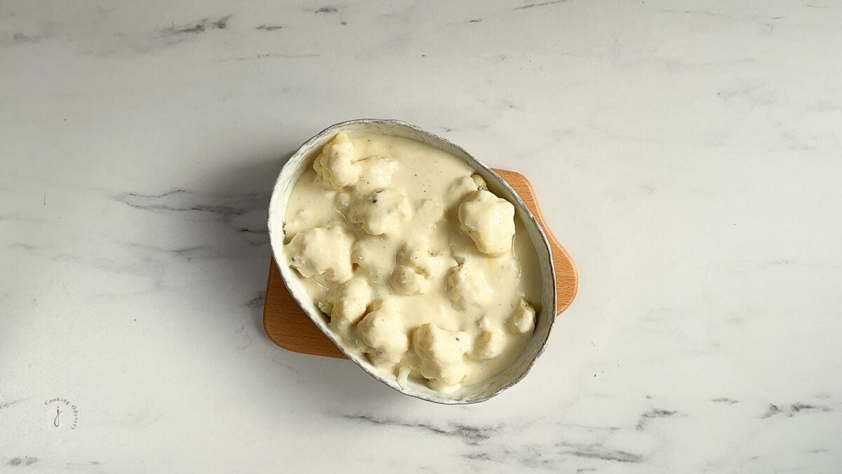 cauliflower cheese sauce poured on blanched cauliflower florets 