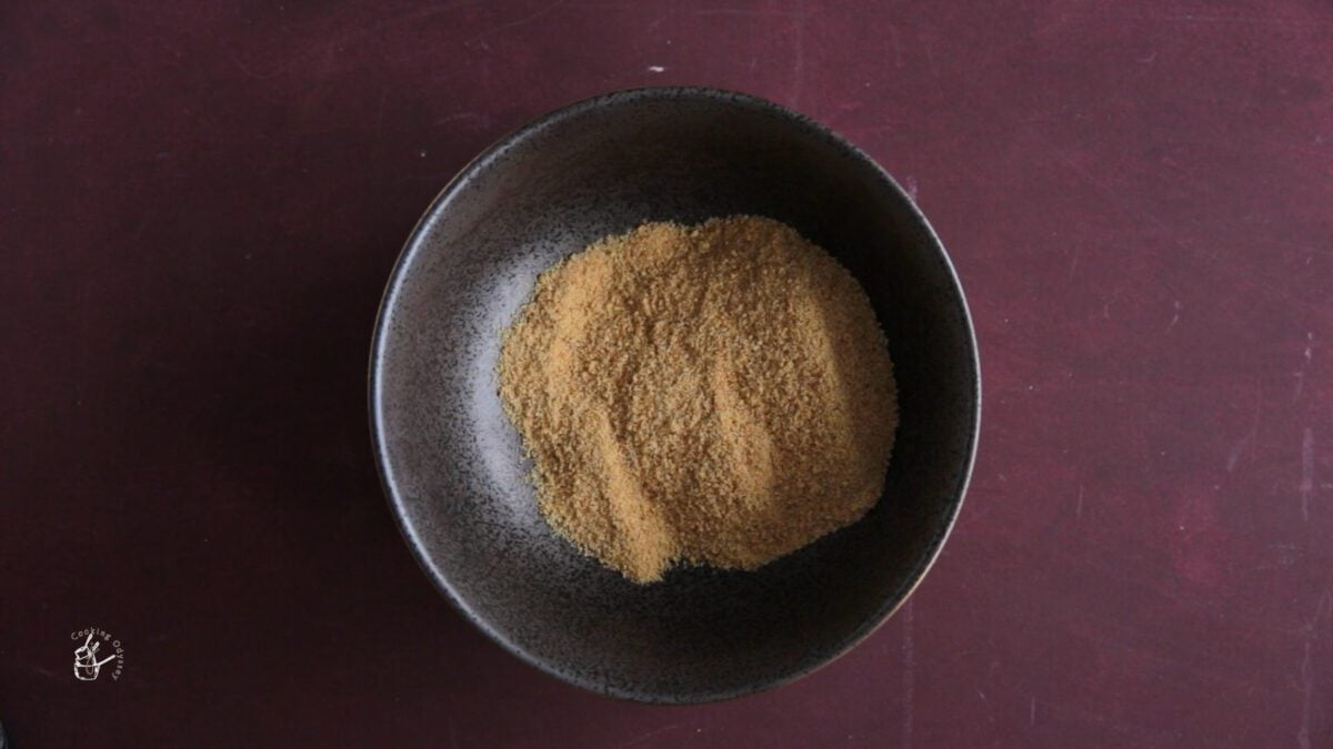 crushed digestive biscuits in a black bowl