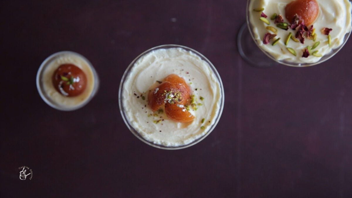three jars of gulab jamun cheese cake garnished with nuts and rose petals