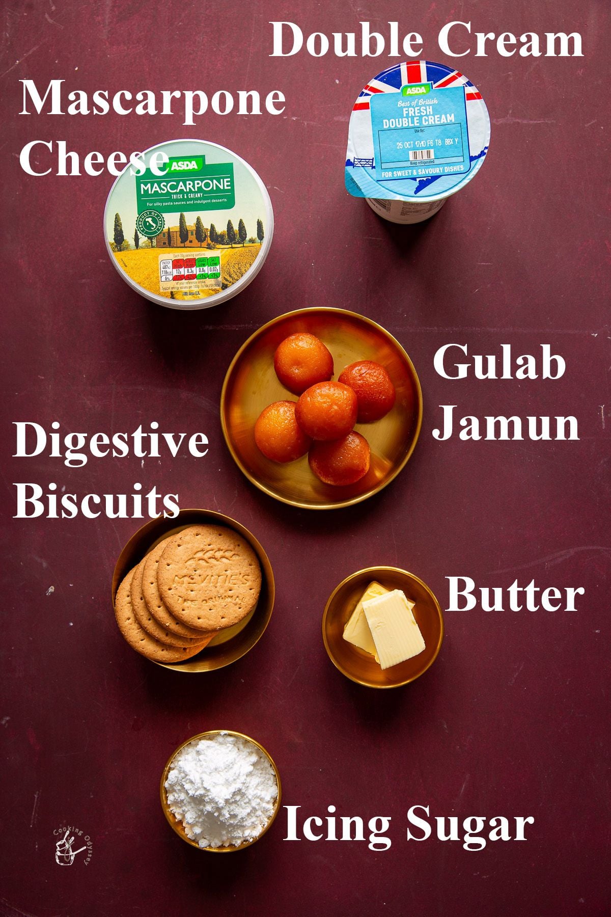 Gulab jamun cheese cake ingredients placed and labeled in brass bowls on purple surface.