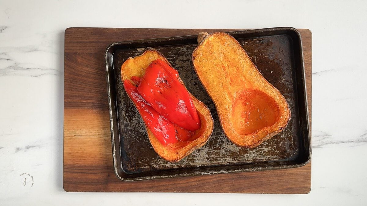 roasted peppers laid on the roasted butternut squash halves 