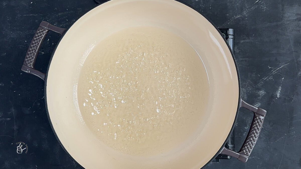 sugar syrup boiling in the pan to prepare badam katli recipe