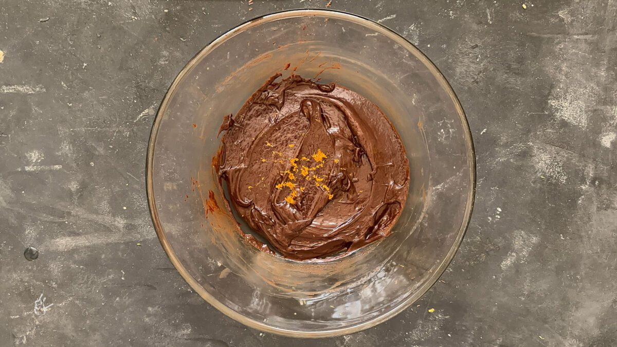 orange zest added to the chocolate ganache in the bowl to make christmas chocolate orange truffles.