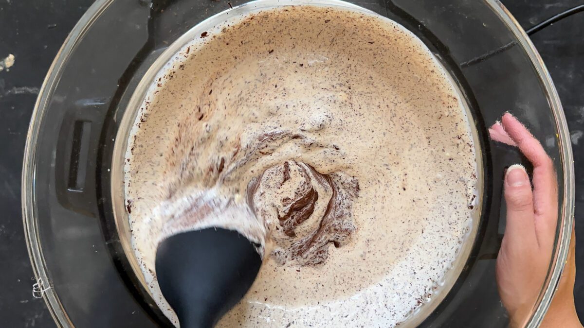 mixing chocolate and cream with a black spatula to prepare christmas decorated truffles 