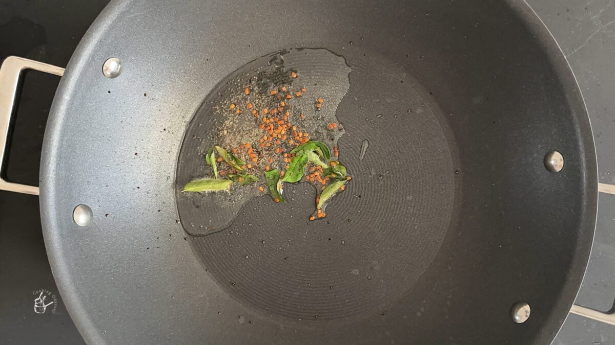 in a wok whole spices added to the hot oil to prepare indian warm cabbage salad.