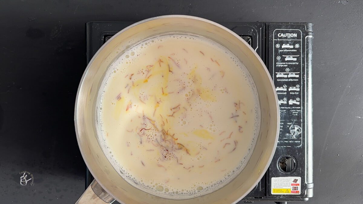 saffron strands added to the boiling milk in the milkpan to make saffron milk.