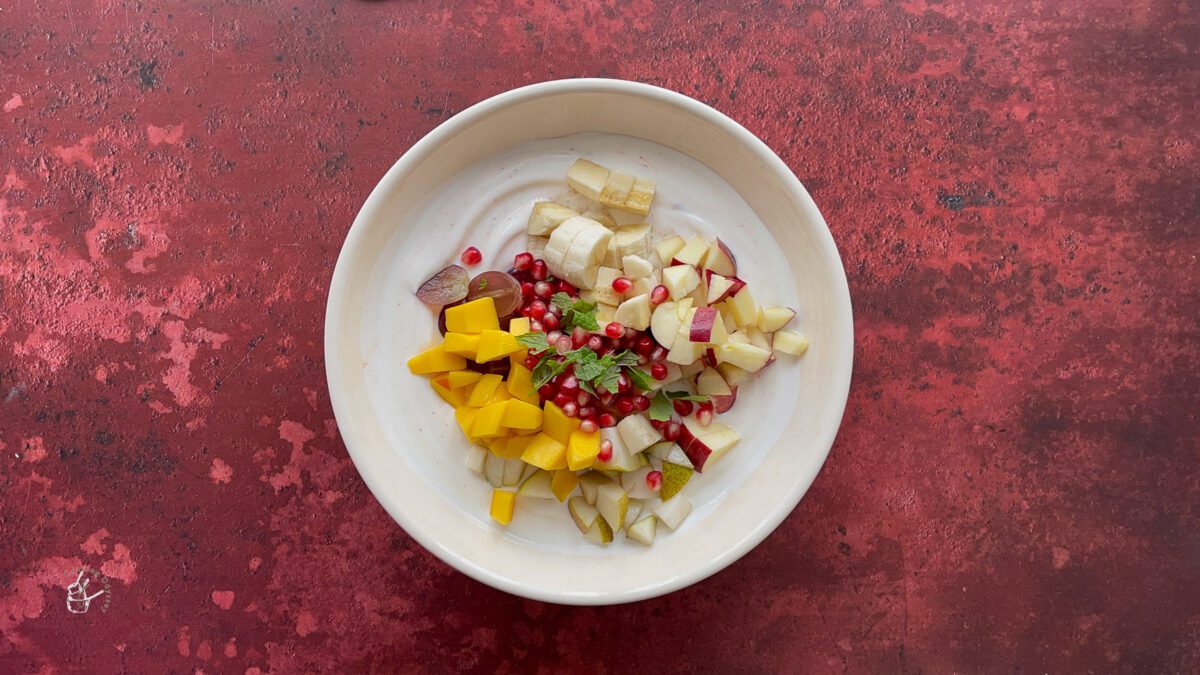 chopped fruits added to the flavoured yogurt in a bowl.