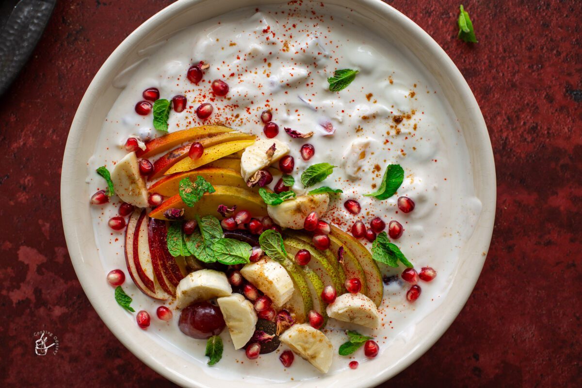 A bowl of healthy mix fruit raita on a table.