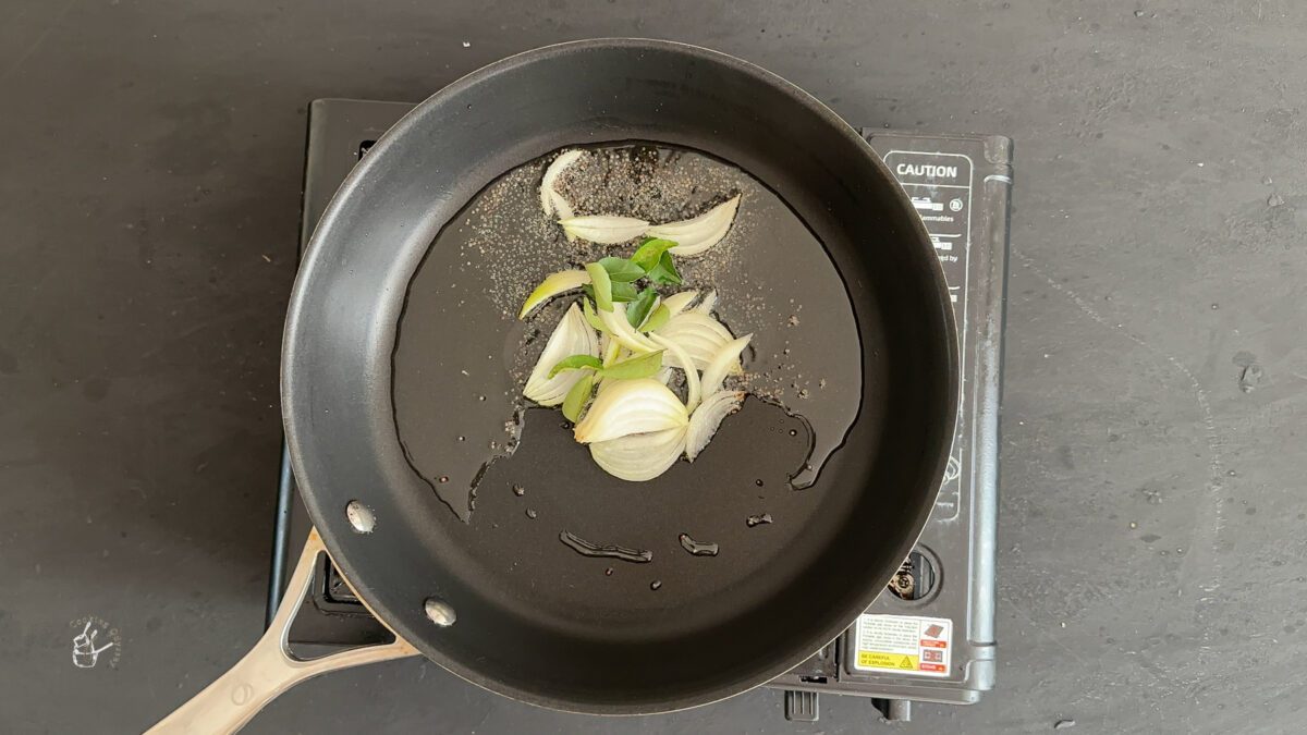 In a hot oil onion, curry leaves and mustard seeds added in the frying pan.