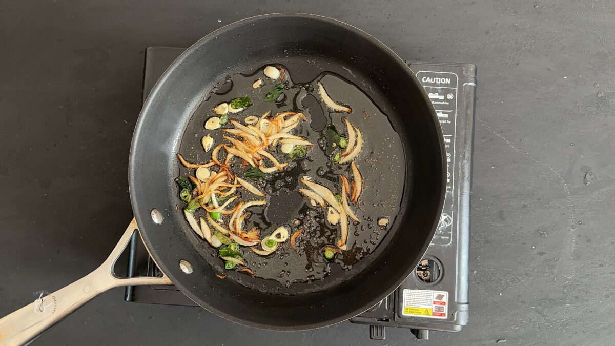 garlic and green chillies added to the sauteed onion in a pan.
