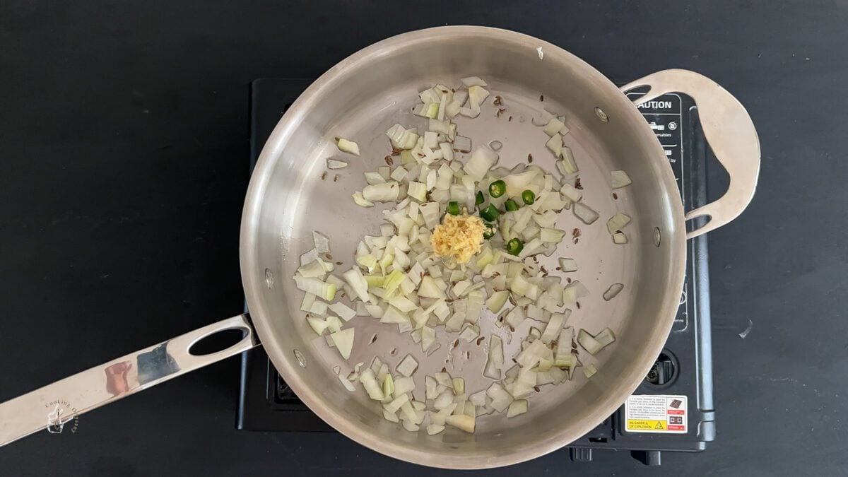 In a pan onion, garlic, ginger and green chillies cooking in hot oil.