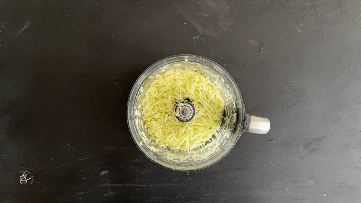 grated raw mango in a food processor bowl.