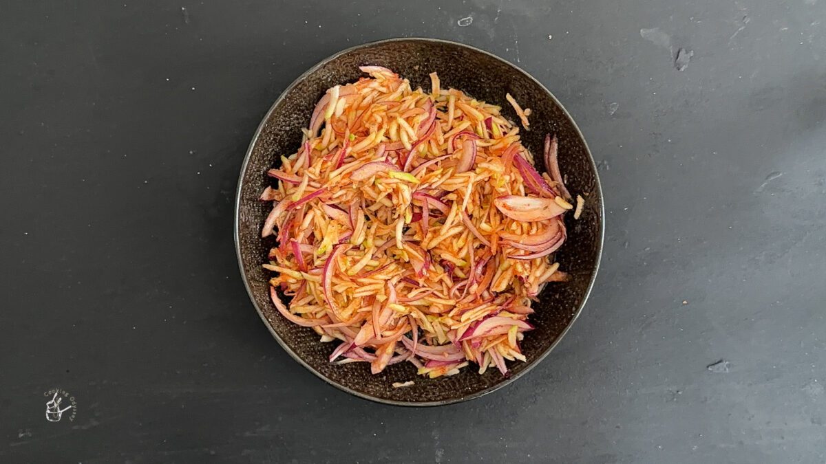 raw mango and onion salad in a bowl on the table.