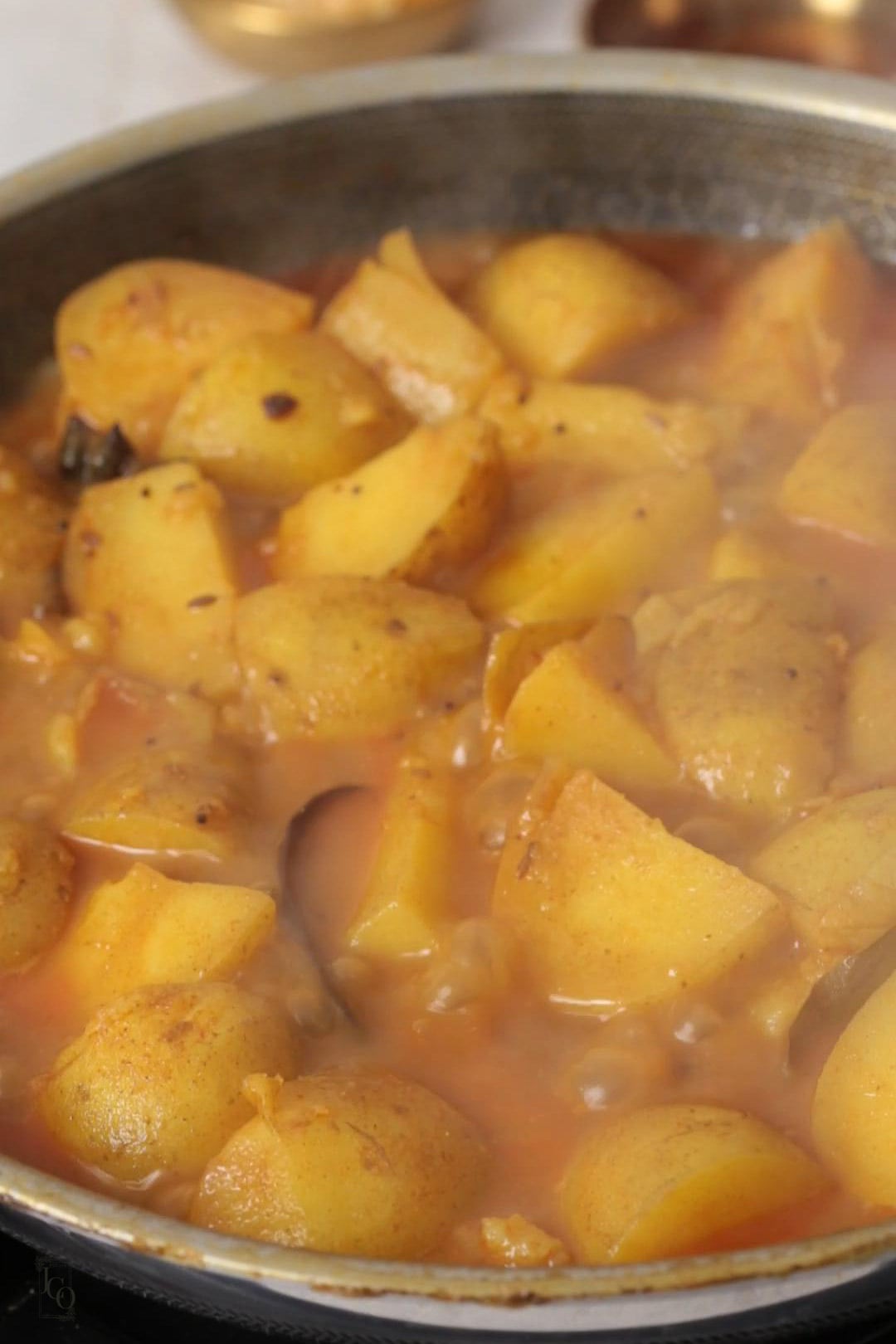 potato curry simmering in a pan.
