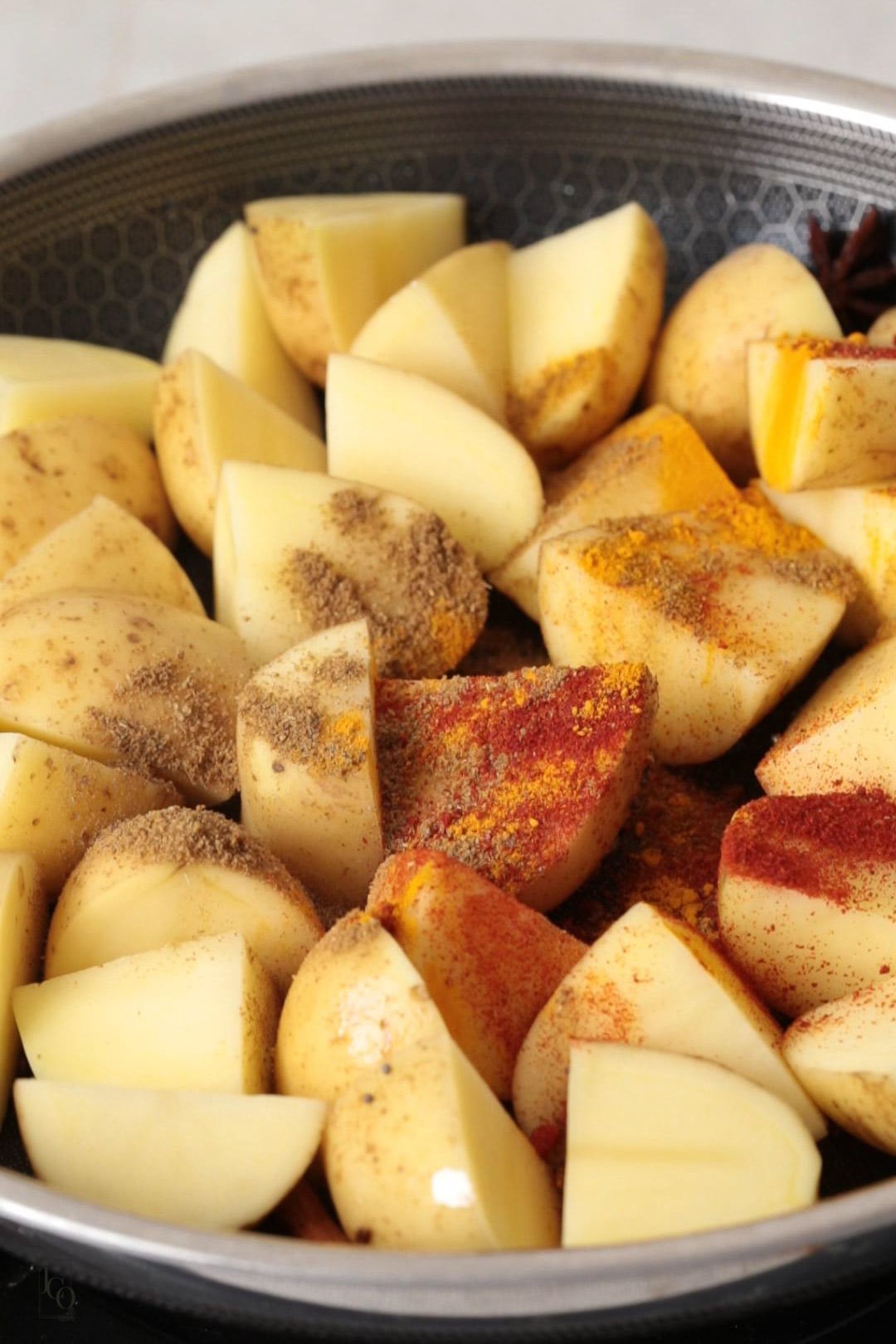 uncooked potato chunks with spice powders.