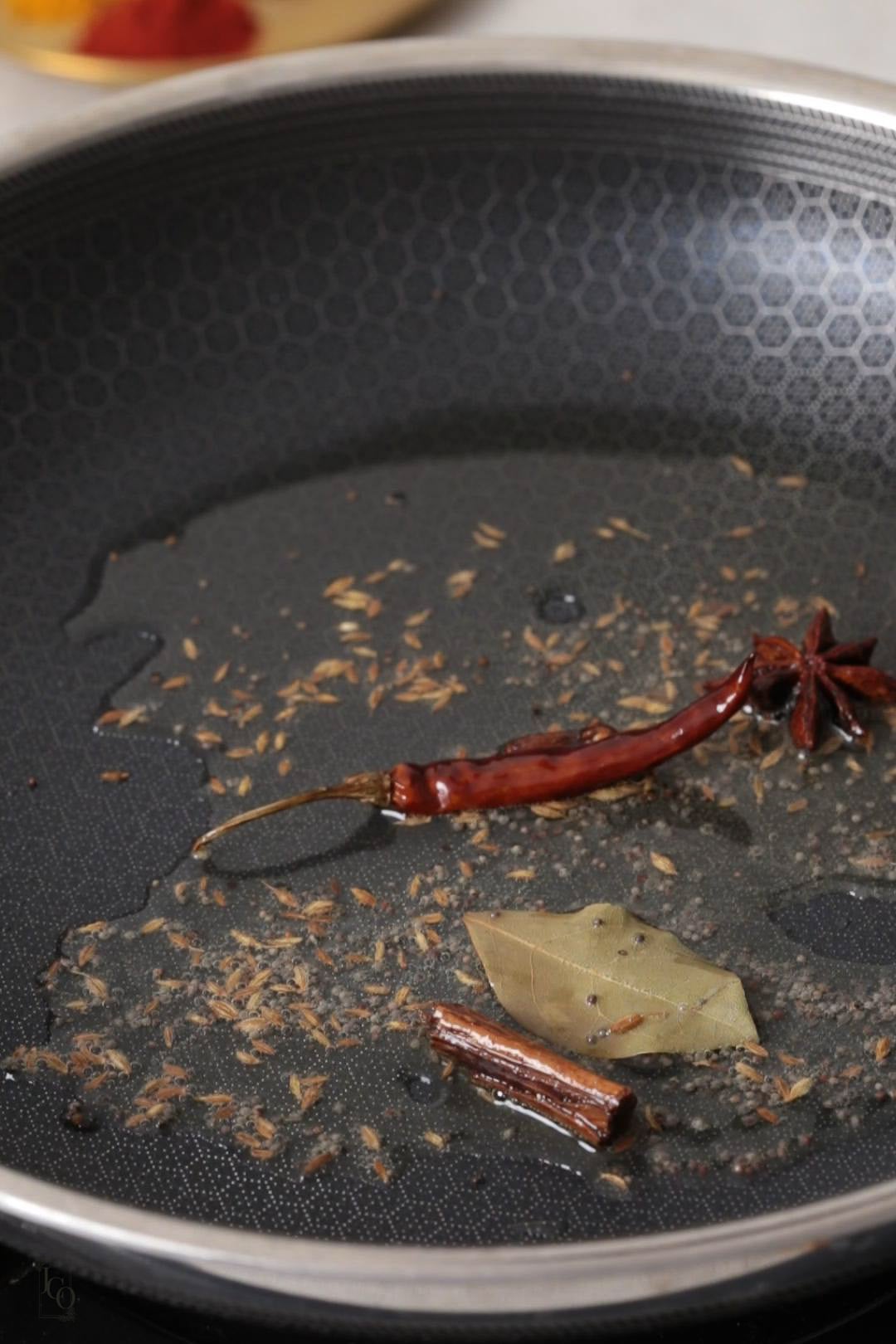 bay leaf, dried red chilli. cinnamon, mustard seeds and cumin seeds tempering in oil.