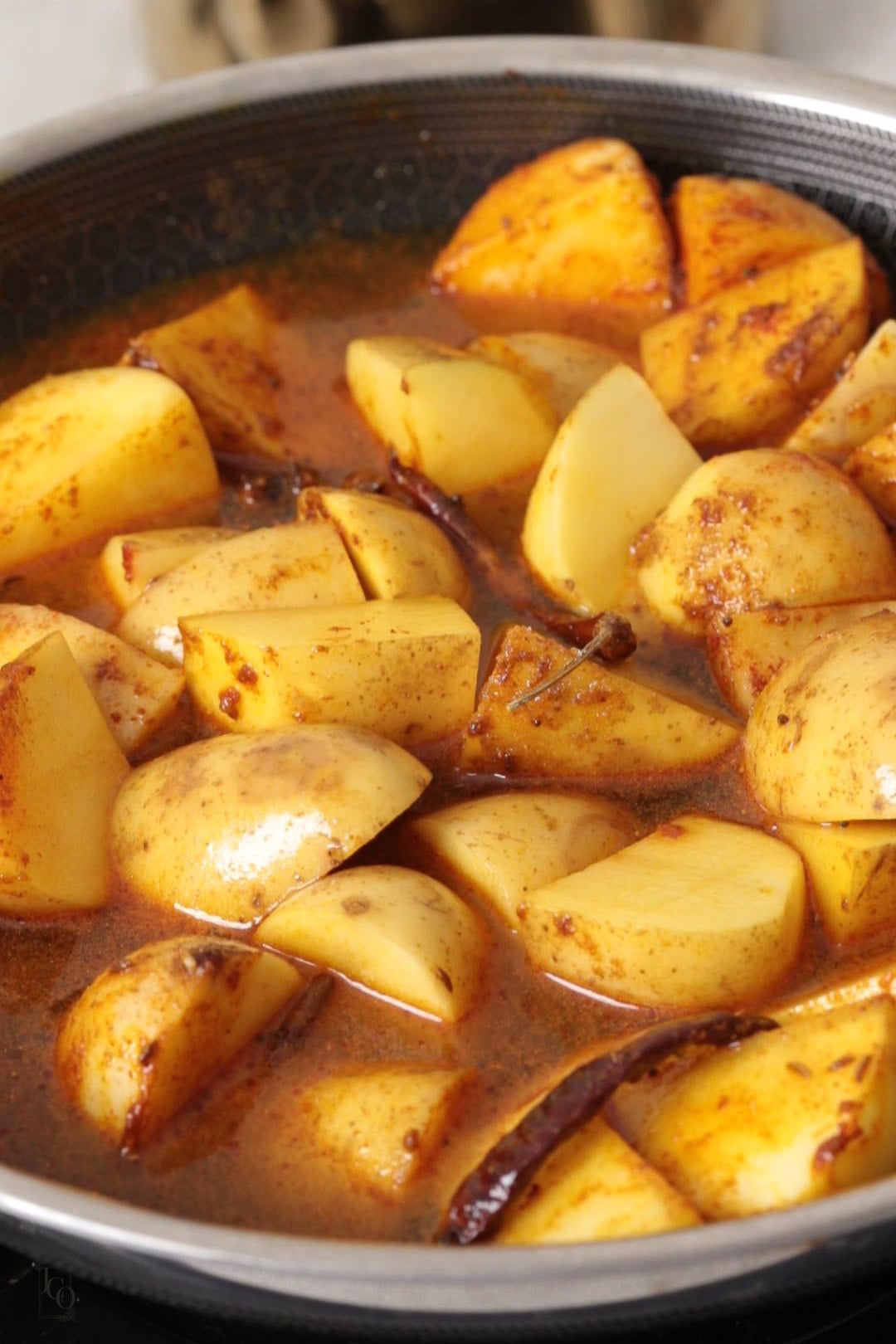 potatoes with watery gravy in a pan.