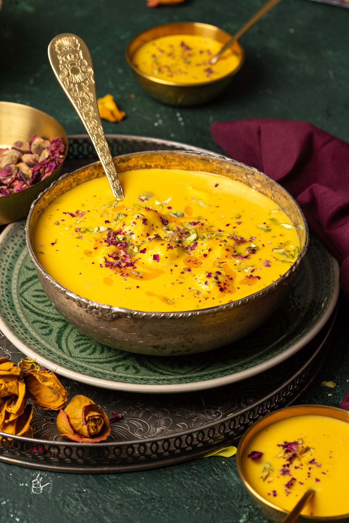 Mango rasmalai served in one big serving bowl and two small bowl with spoons.