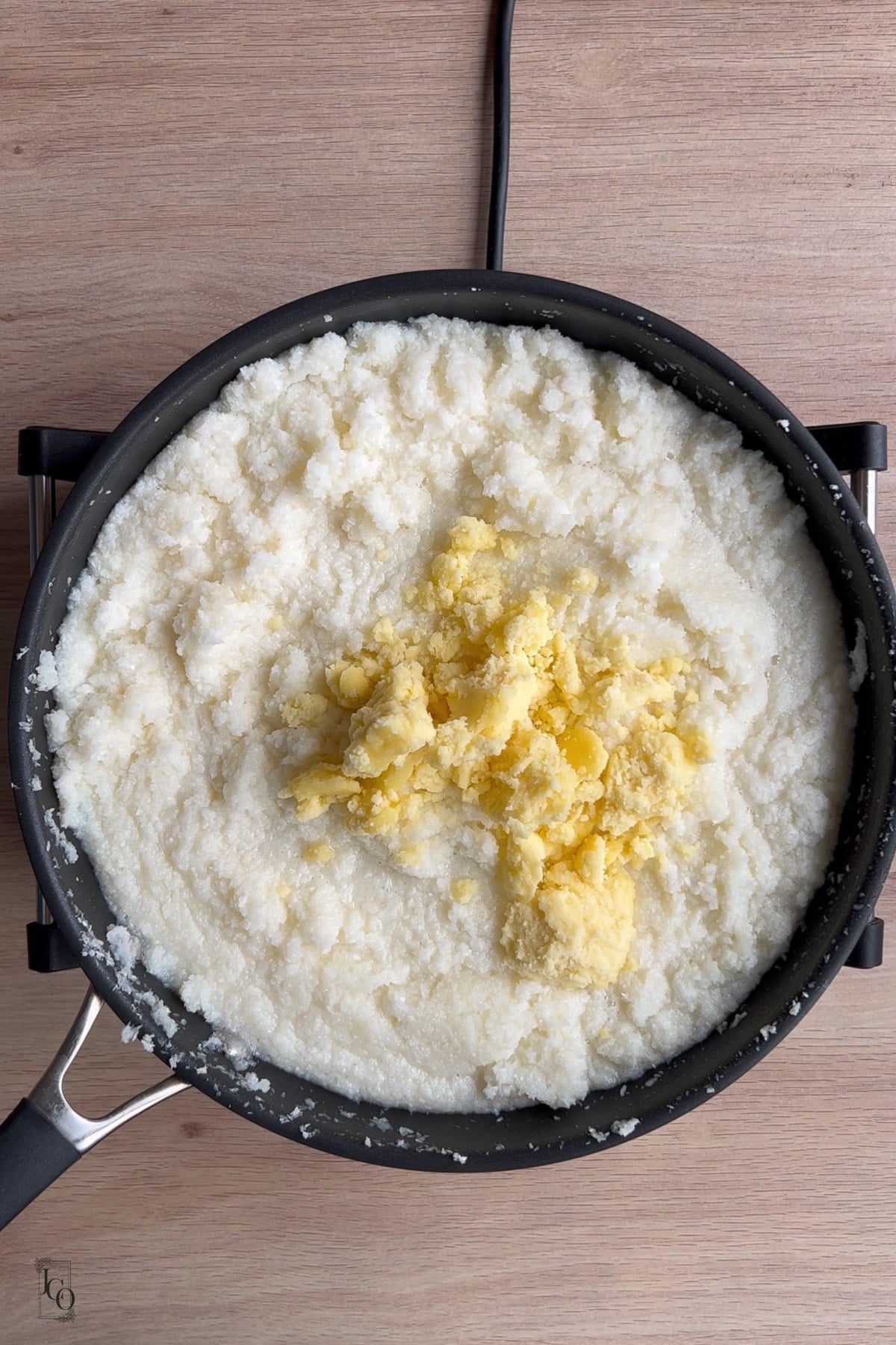 Mawa added to the coconut barfi mixture in a pan. 