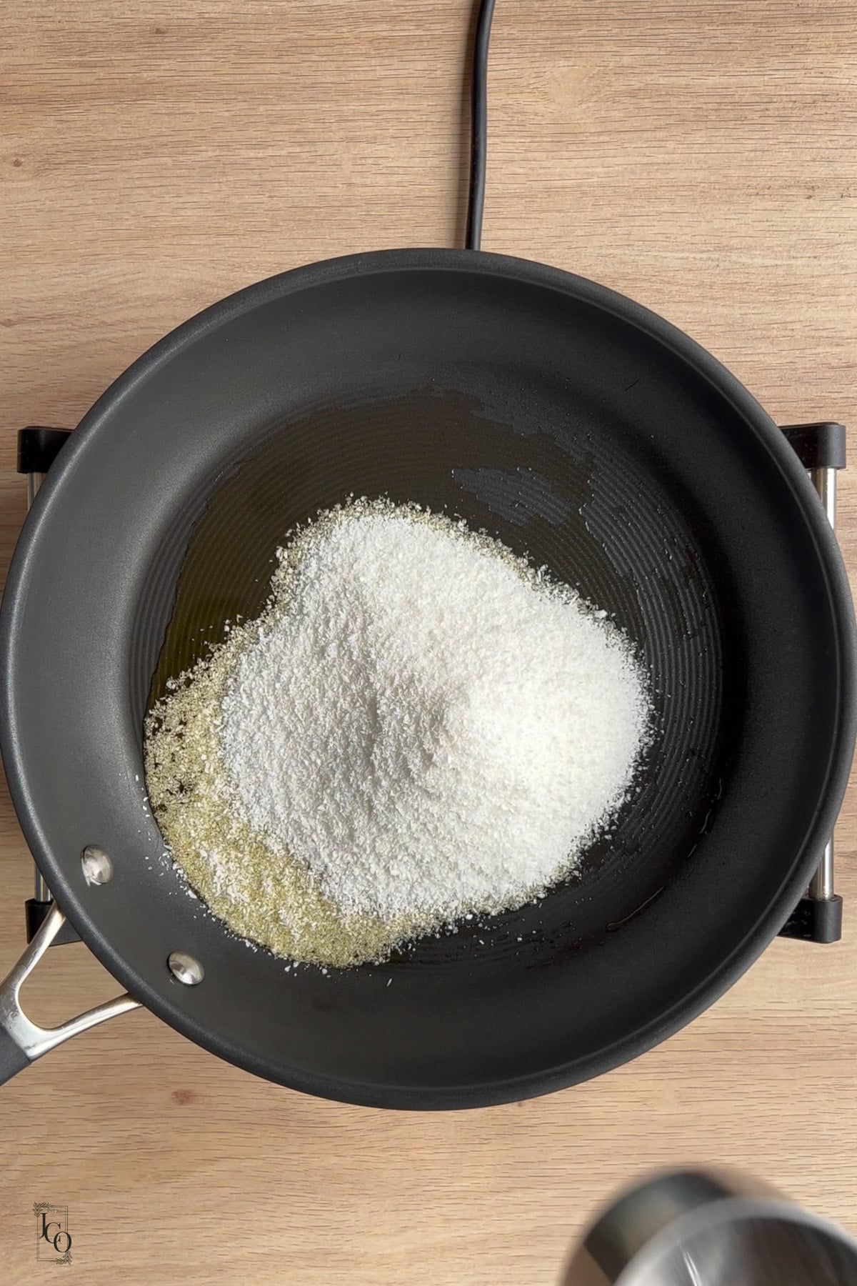 Melted ghee and desiccated coconut in a pan. 