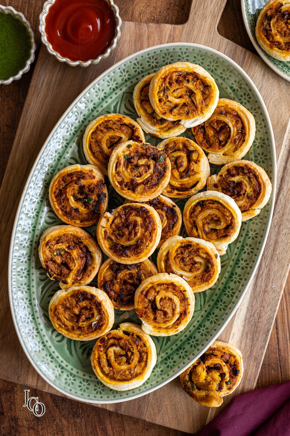 Indian fusion appetiser kachori pinwheels are arranged on a serving plate.