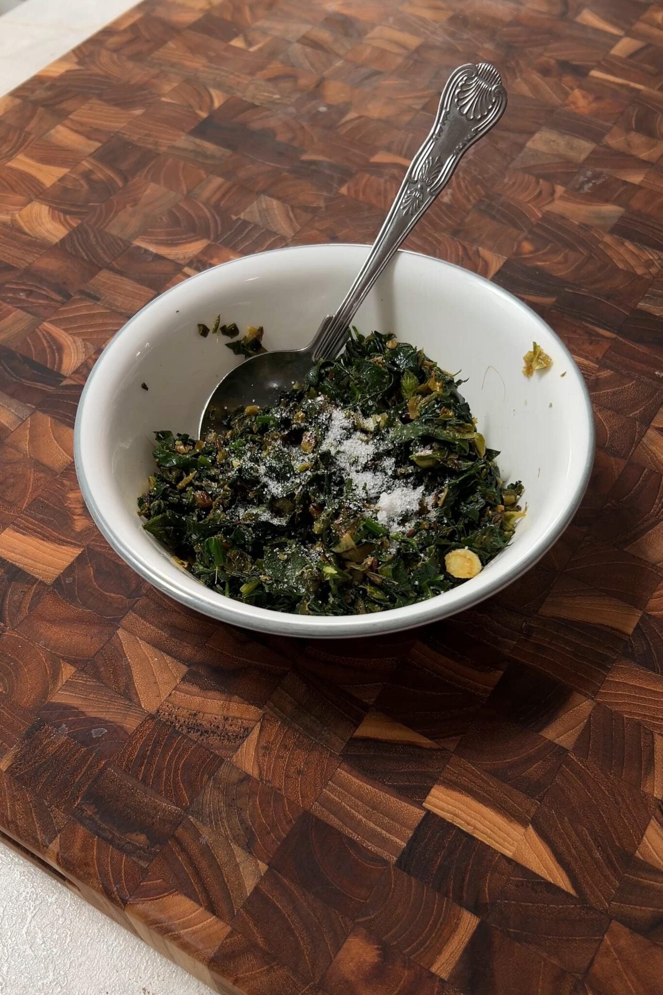 Salt added to the rotla stuffing in a white bowl.