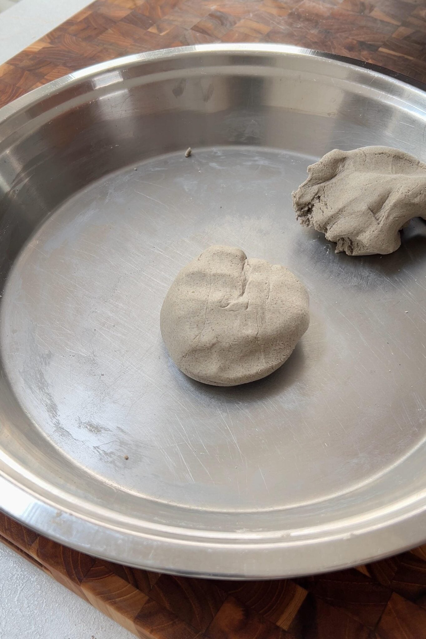 Two equal parts of millet flour dough in a plate.