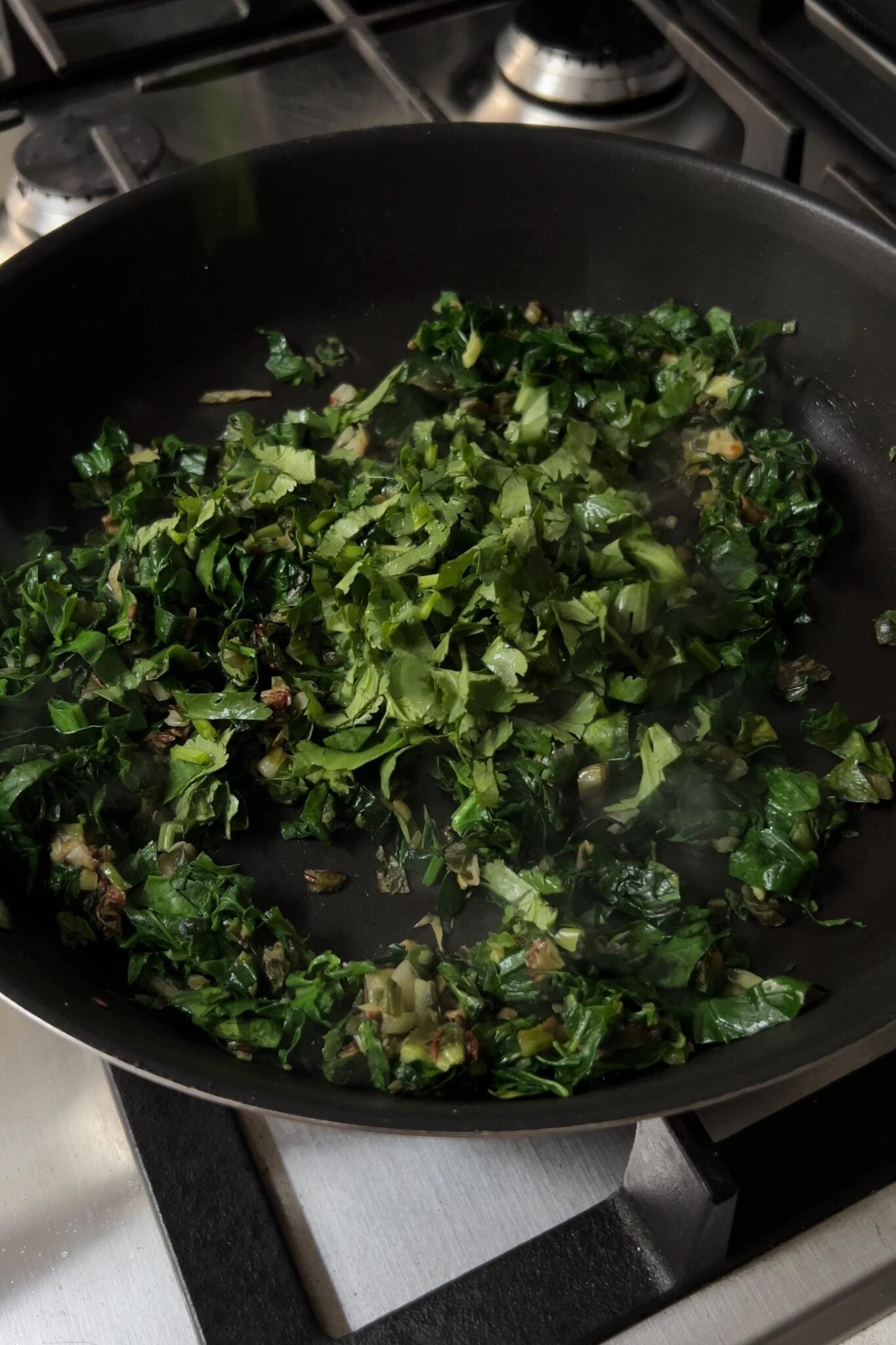 Greens added to the pan.