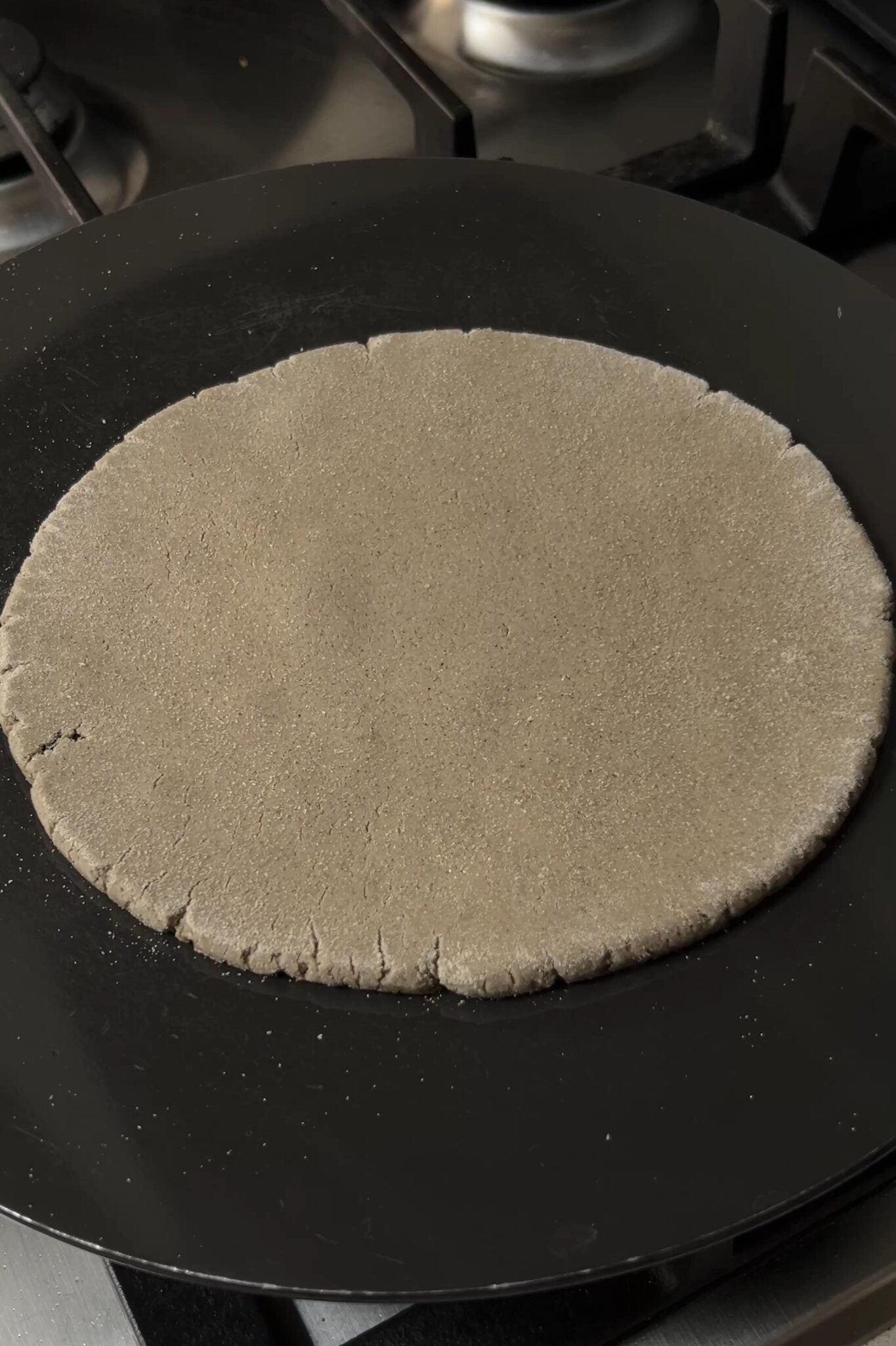 Stuffed bajra rotlo on a hot griddle.