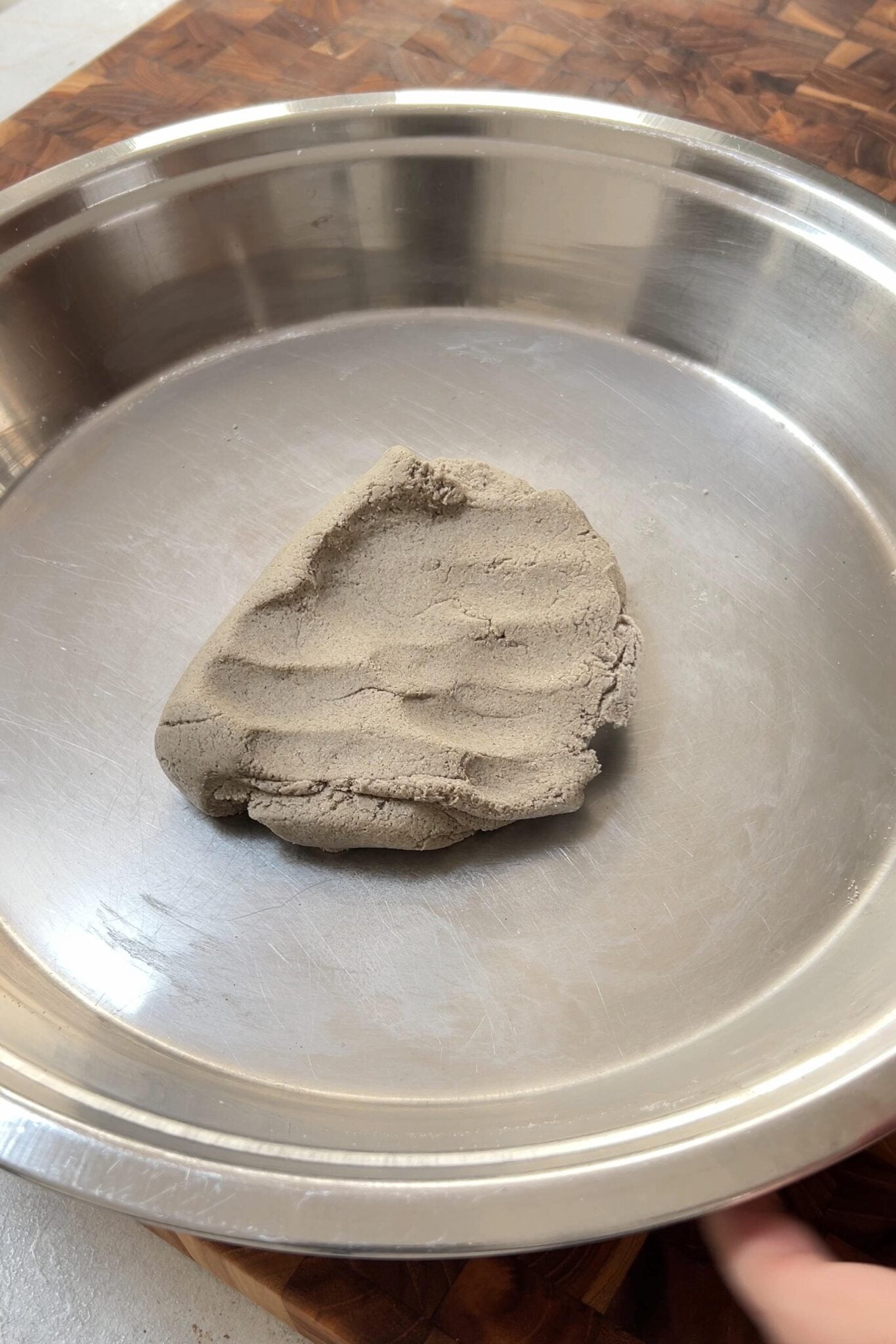 Ball of Millet flour in a round stainless steel plate.