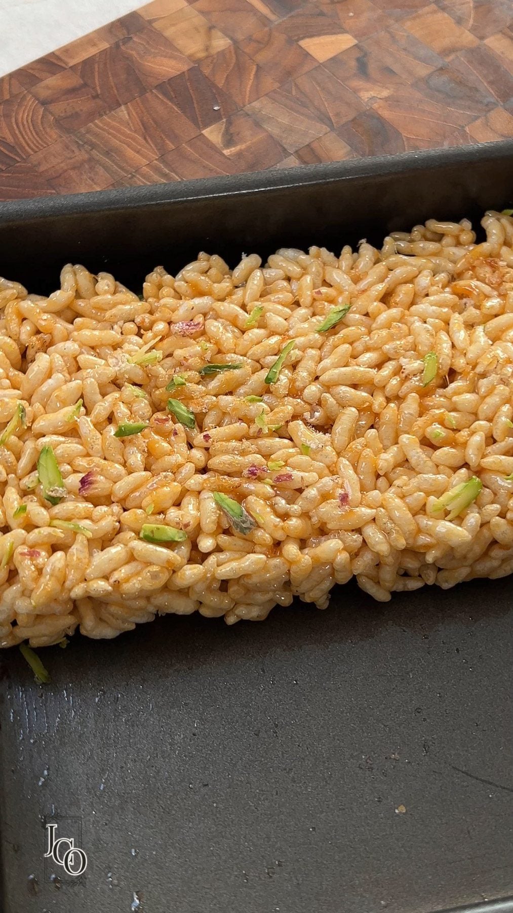 Mamra ladoo mixture apread evenly in a tray to make squares.