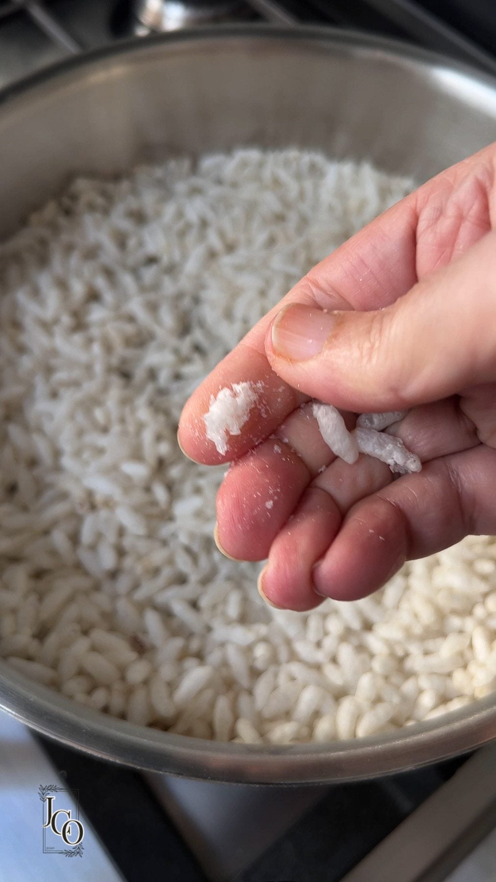 Female hand is showing roasted crispy mamra on her fingers by pressing.