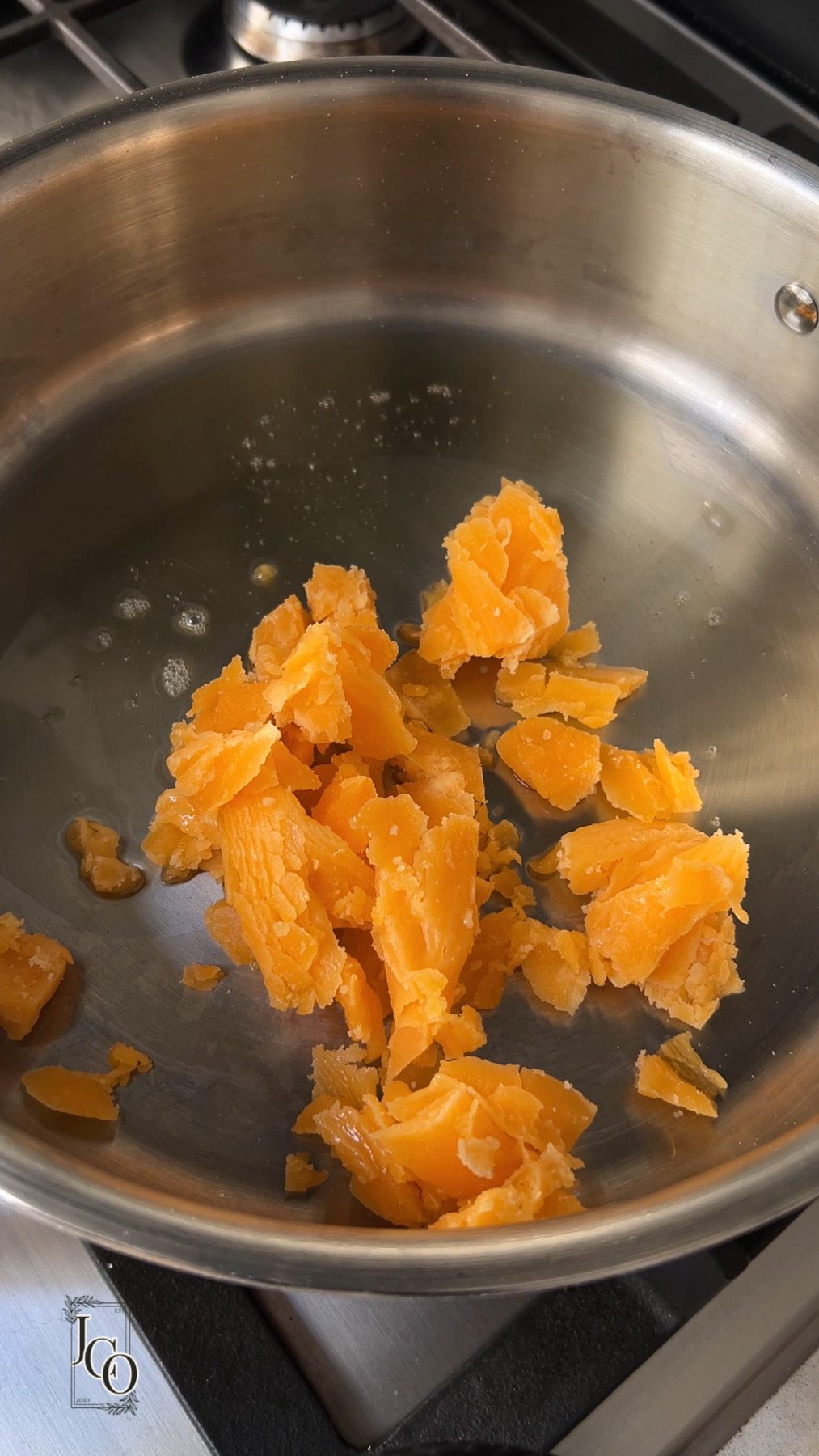 Grated jaggery added to the melted ghee in a pan.