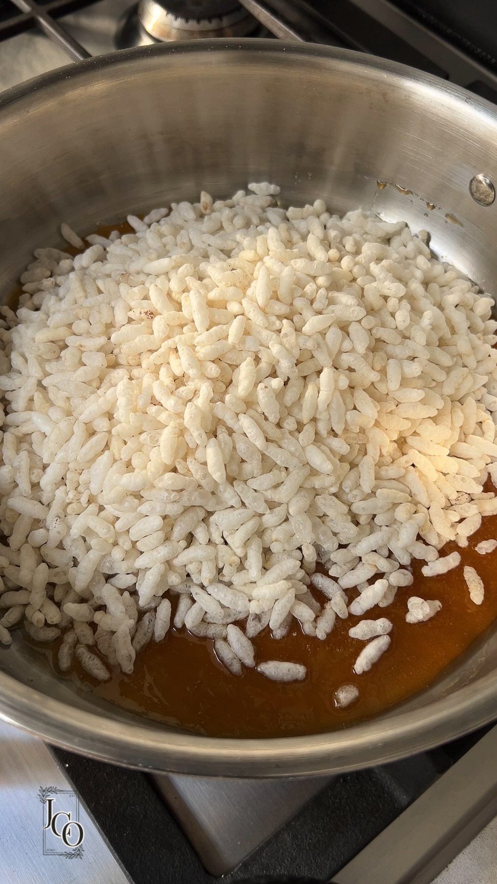Dry roasted mamra added to the hot jaggery syrup in a copper pan.