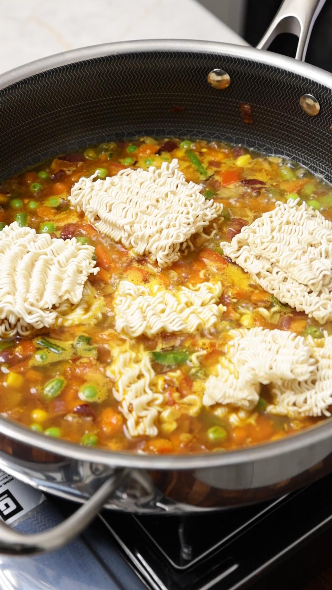 Maggi noodles added to the boiling mixed vegetables.