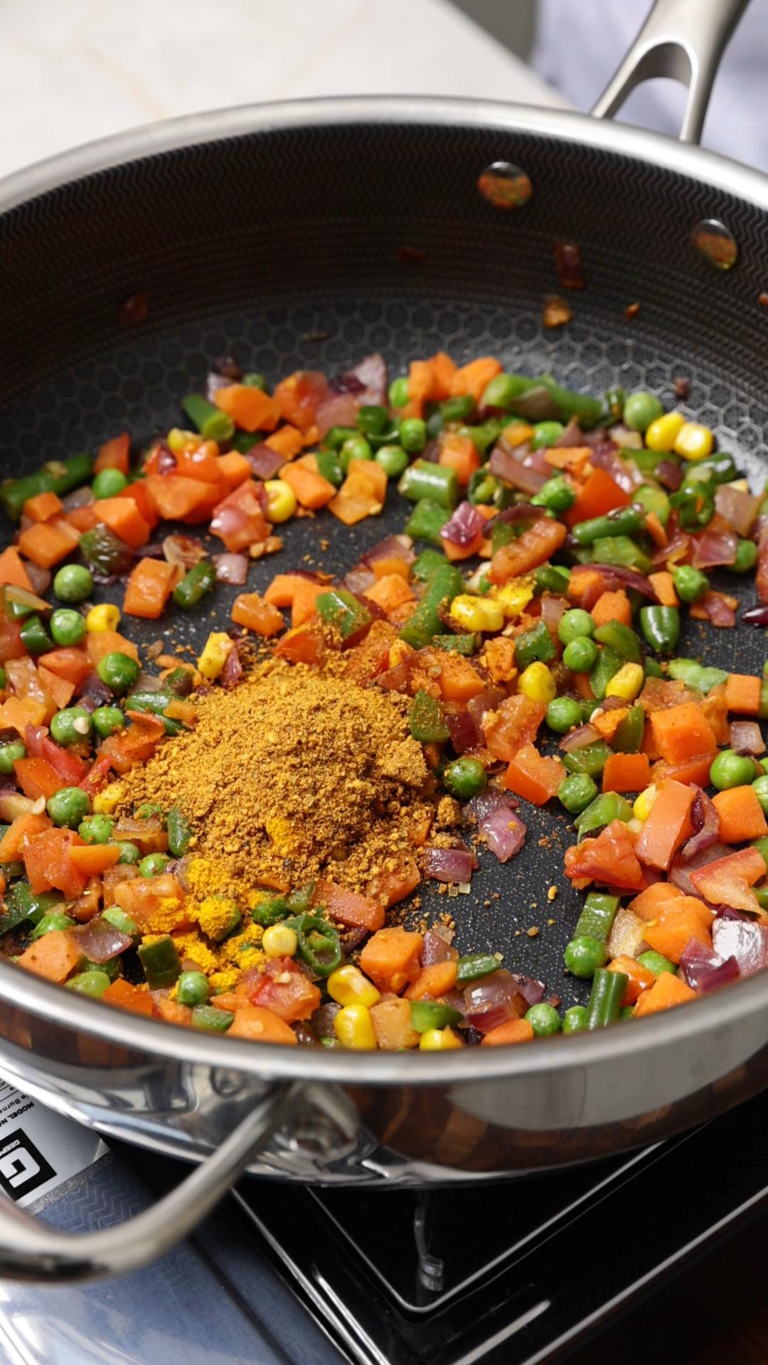 Dry spices powders red chilli, powder, turmeric powder and maggi masala added to the cooked mix vegetables.