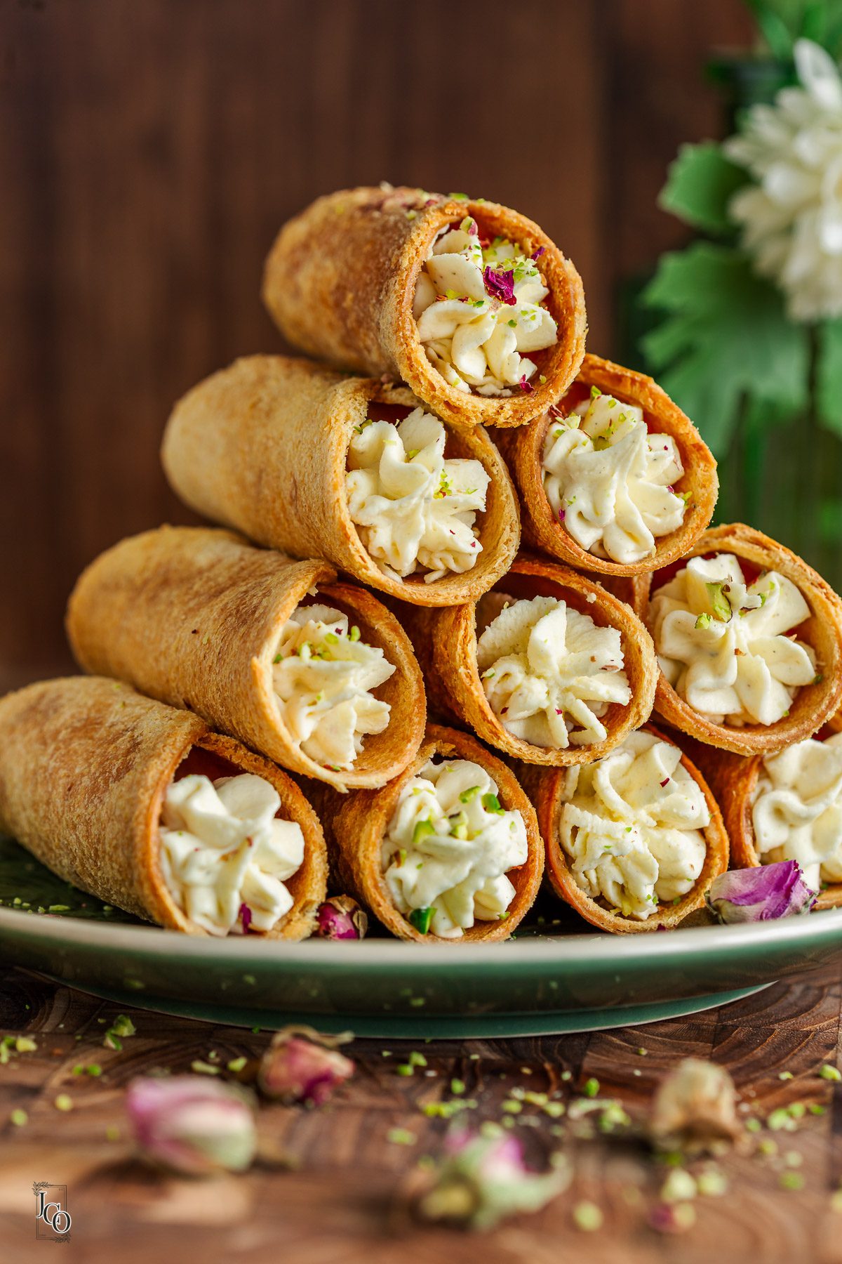 10 Cardamom cannoli pieces arranged in a stack on the green serving plate.