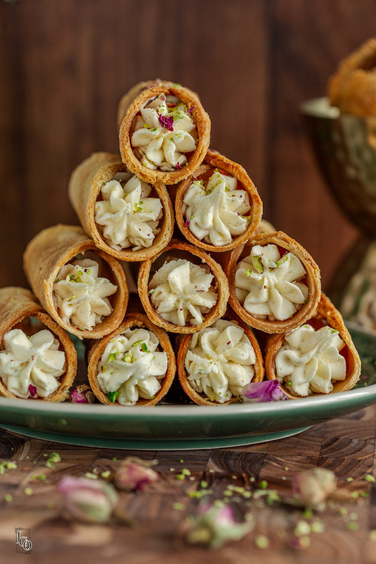 Cardamom cannoli arranged on a green serving plate. 