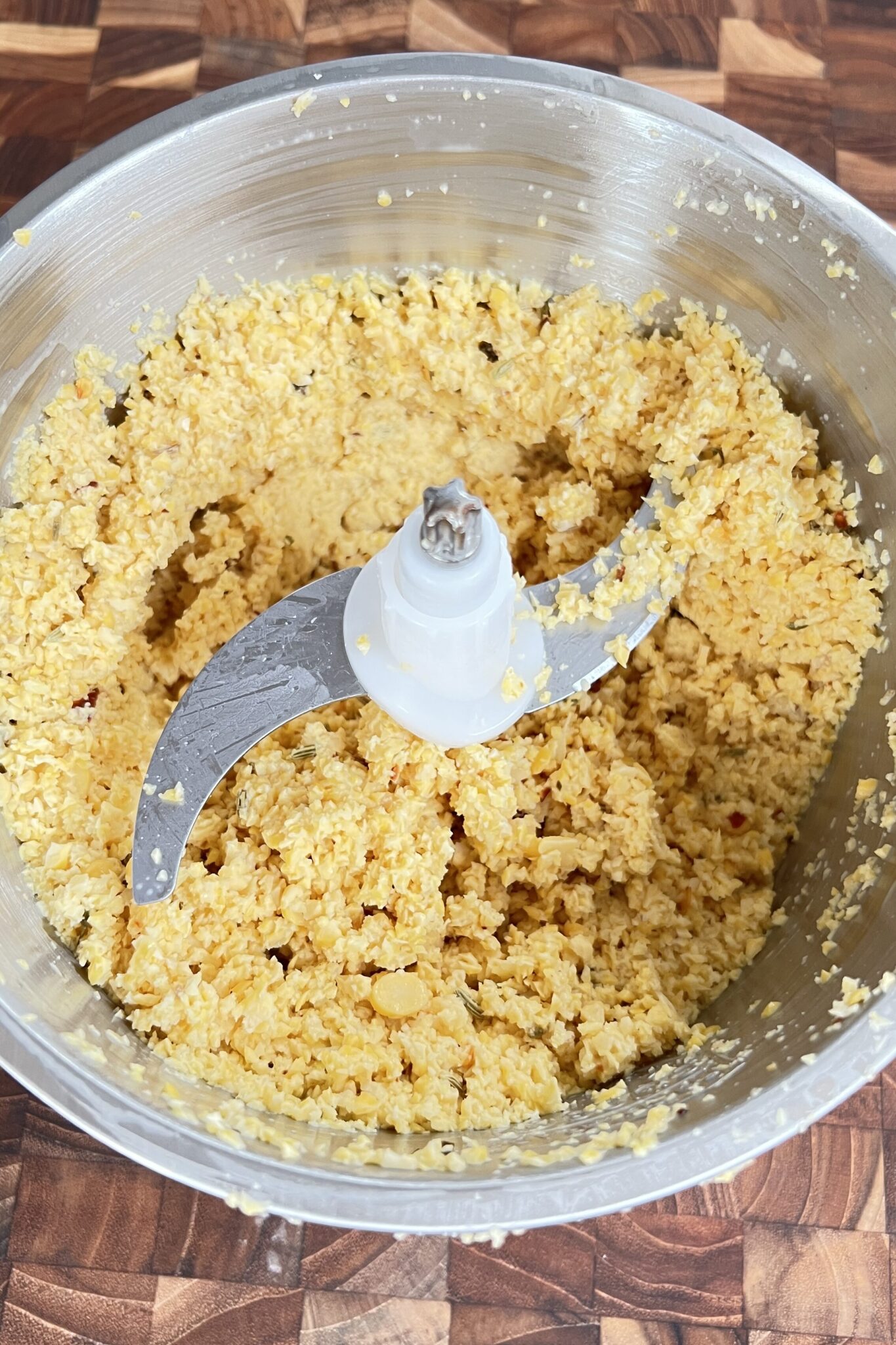 Coarse ground chana dal in a grinder with spices.