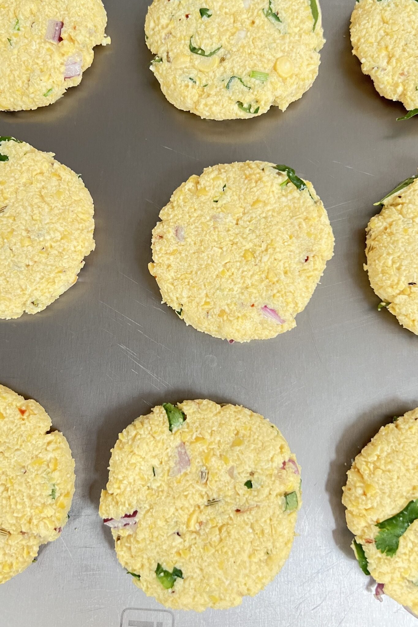 Raw chana dal vada pattise placed on a chopping board.