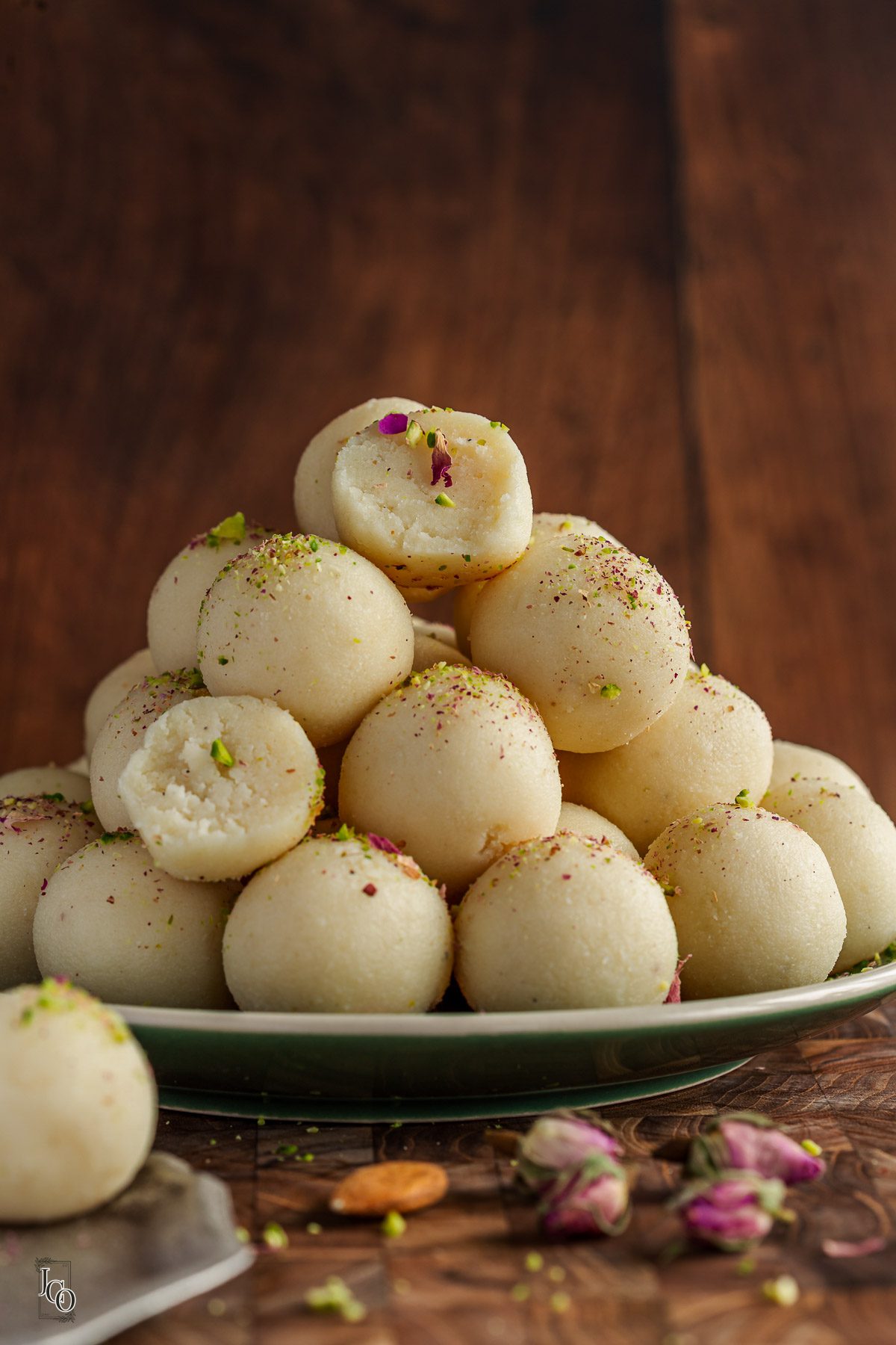 Coconut almond ladoos arranged on a green serving plate.
