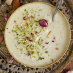 A bowl of makhana kheer placed on a metal serving tray.